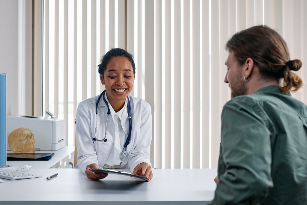 A doctor sitting at the table with a patient.