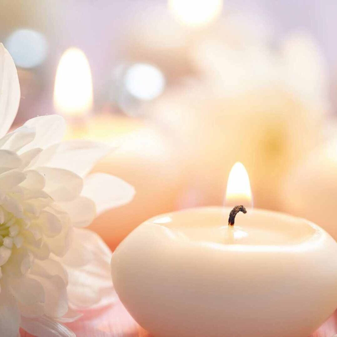 A candle and some flowers on a table