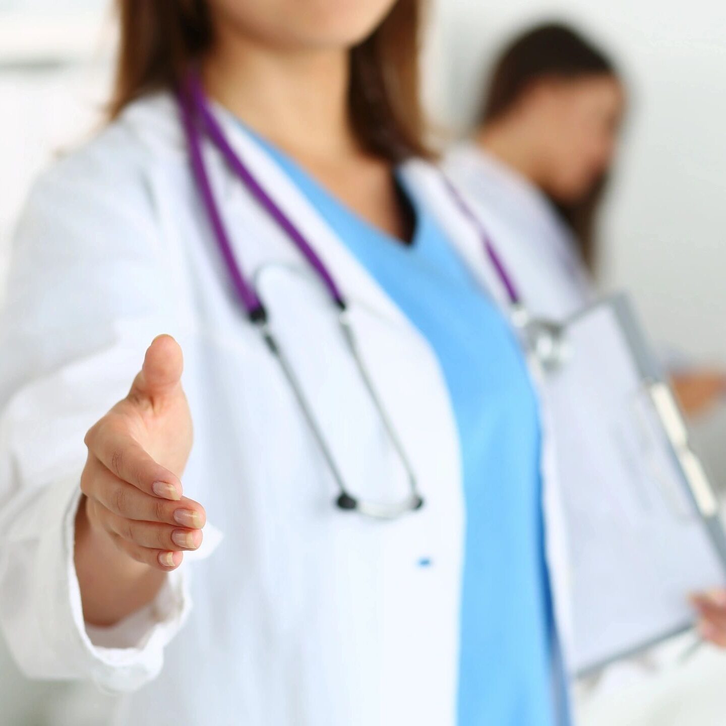 A woman in white lab coat holding out her hand.